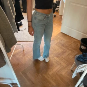 Ljusblå bootcut jeans från Gina Tricot - Säljer ett par ljusblå bootcut jeans från Gina Tricot, modell Perfect Jeans. De har låg midja, klassisk femficksdesign och snyggt utsvängda ben. Jeansen är i mjukt denimtyg och har en skinnpatch bak i midjan.