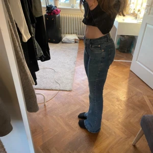 Blå bootcut jeans från Gina Tricot - Snygga blå jeans från Gina Tricot med bootcut-modell och klassisk femficksdesign. Jeansen har låg midja och är tillverkade i stretchig denim som sitter skönt och formar sig efter kroppen. Perfekta för dig som gillar en retroinspirerad look.