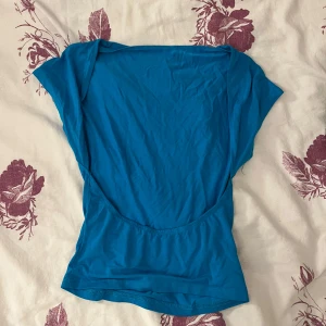 Blå topp öppen rygg - Blå topp med öppen rygg i storlek XS. Super skönt och stretchigt material.