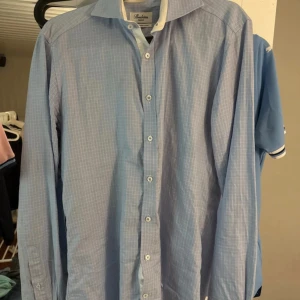 Blå rutig skjorta Stenströms Slimline - Snygg blå skjorta från Stenströms i slimline-modell. Skjortan har ett diskret rutigt mönster, klassisk krage med vit insida och knäppning framtill. Tillverkad i exklusiv twofold super cotton som känns riktigt skön mot huden. Perfekt för dig som gillar stilrena detaljer.