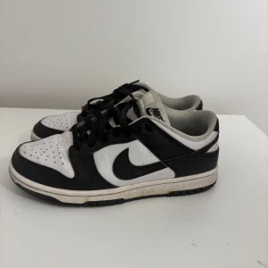 Nike Dunk Low panda - Nike Dunk Low sneakers i svart och vitt med klassisk design. Lite creasade o smutsiga men går att tvätta enkelt 
