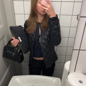 Svart quiltad jacka - Säljer en populär, stilren svart quiltad jacka från uniqlo. Jackan har en figurnära passform och långa ärmar, perfekt för kyligare dagar. En mångsidig jacka som funkar till många olika outfits. Ganska tunn så perfekt till våren eller kyligare sommardagar/kvällar!!