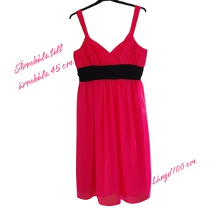 Somrig klänning i tunn polyester – ceriserosa m markerad midja. Stl 38. Nyskick. - Ceriserosa klänning i polyester med ett stilrent svart band. Perfekt för både fest och vardag! Klänningen har en smickrande passform och ett mjukt, följsamt tyg som sitter bekvämt. Nypris 2 000 kronor.  *Färg: Ceriserosa med svart band *Material: Polyester – lätt och skrynkelfritt *Passar till fest, bröllop, eller vardags. Nyskick och med prislapp.