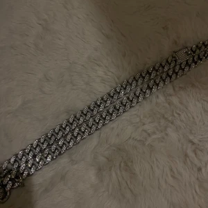 kedja i silver - Snyggt halsband med breda länkar i silverfärg, dekorerat med glittrande stenar. Perfekt för att ge en extra touch till din outfit. Låset är fyrkantigt och prytt med små stenar för extra bling.