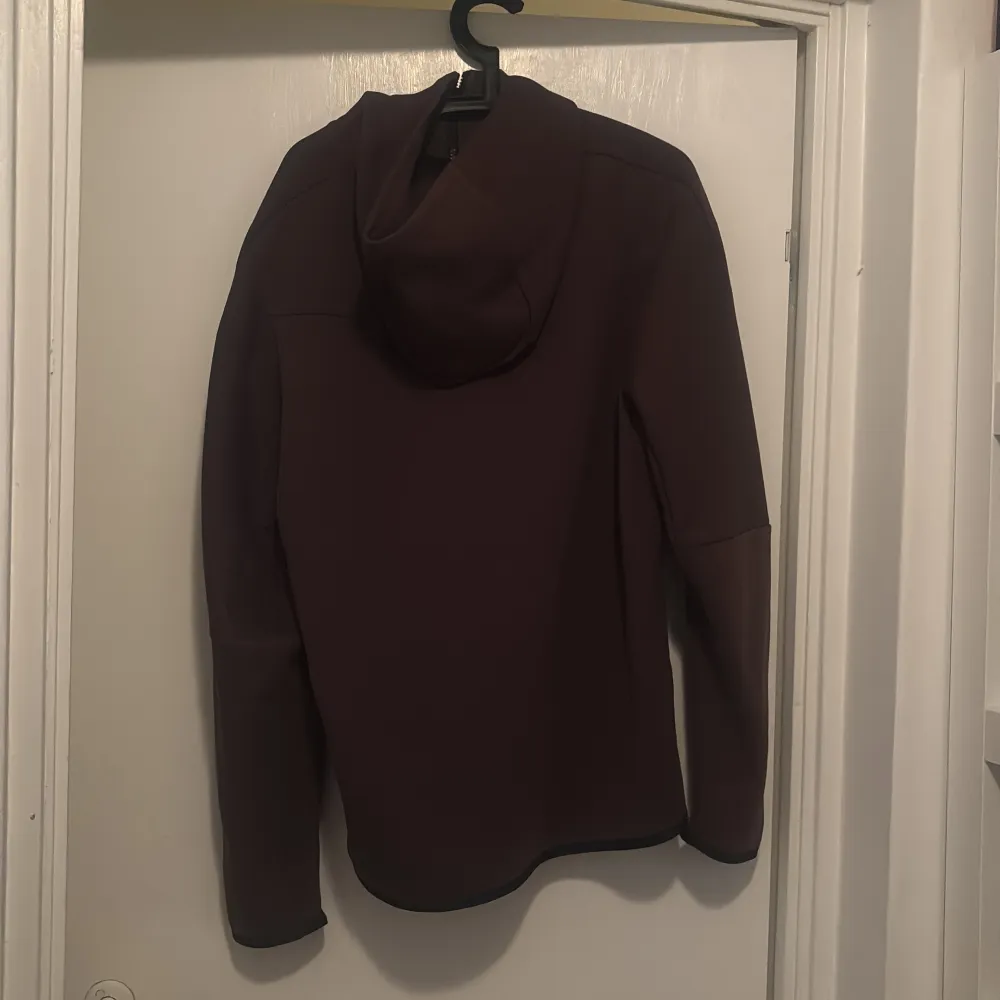Säljer en brun kofta från Nike med dragkedja och huva. Koftan har en stilren design med långa ärmar och diskreta detaljer. Perfekt för en sportig look eller en avslappnad dag. Koftan är i storlek L och använd ett par gånger hemma. Aldrig utomhus . Takit.