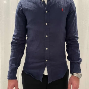 Ralph Lauren skjorta - Säljer en mörkblå ralph lauren skjorta som är helt ny!! Materialet är linne och perfekt till sommaren!! Storlek s, köpte den för 2000kr på inside och säljer den för 599kr!!