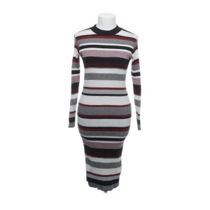 Halv polo randig flerfärgad klänning strl 38  - Snygg randig klänning från Atmosphere i svart, vit och vinröd. Klänningen är stickad och har en tight passform med långa ärmar. Perfekt för en stilren look! Halv polo randig flerfärgad klänning strl 38 med långa ärmar och ett randigt mönster i färgerna svart, vinröd, grå och vit.