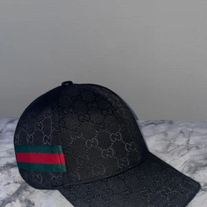 Svart keps från Gucci - Snygg Gucci keps som jag tyvärr måste säga hejdå till, fick den i födelsedagspresent men hade redan beställt en annan keps så har ingen användning av denna, den är i nyskick då jag endast haft på mig den för att ta en bild med den