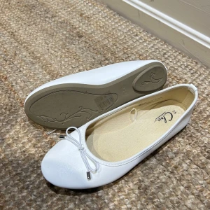 Vita ballerinaskor med rosett - Snygga vita ballerinaskor med rund tå och en söt rosett framtill. Perfekta för en stilren look.