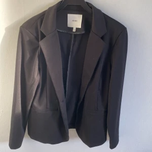 ICHI kavaj - Jättefin kavaj från ICHI,  köpt på Åhléns. Mjukt och följsamt material som ger en fin figur. Använd ett fåtal gånger. Stl xl. Är svart även om bilderna är bleka.