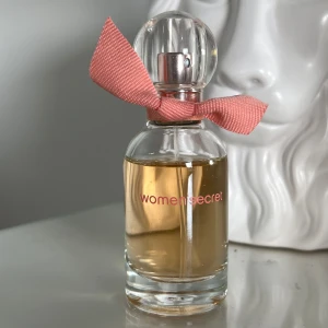 Eau My Secret Eau de Toilette från Women'secret - En elegant Eau de Toilette från Women'secret med en fräsch och blommig doft. Toppnoter av björnbär, mellannoter av mandel, jasmin, apelsinblomma och ros, samt basnoter av vanilj och vit cederträ. Flaskan rymmer 30 ml och pryds av en söt rosa rosett. Jag har använt ca 3ml från parfymen. Har inte kvar originalförpackningen. Perfekt att ge till någon i present💐