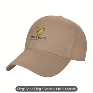 Sandfärgad keps från Lyle & Scott HELT NY - Snygg sandfärgad keps från Lyle & Scott med deras ikoniska gula logotyp framtill. Perfekt för en stilren och avslappnad look. Kepsen har en klassisk design med böjd skärm och justerbar rem baktill.
