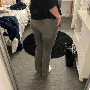 Grå bootcut jeans från Esprit - Snygga grå bootcut jeans från Esprit. De har en klassisk femficksdesign och en bekväm passform. Perfekta för en avslappnad stil. Midjan är låg och byxorna har en lätt utsvängd bootcut-stil.