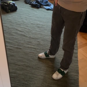 Grå Levis 501 - Säljer ett par grå jeansbyxor från levis med klassisk femficksdesign och knappgylf. Byxorna har en rak passform och är perfekta för en avslappnad stil. De har också de ikoniska nitarna vid fickorna