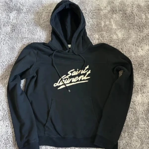 Saint Laurent Hoodie - Säljer en stilren svart hoodie från Saint Laurent. Den är i grymt skick och inget og följs med. Ny pris 9500 kr. Storlek M passar även S. Skriv vid minsta fundering