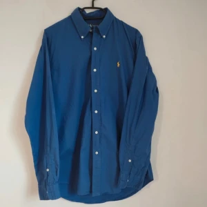 Blå skjorta från Ralph Lauren - Snygg blå skjorta från Ralph Lauren. Perfekt för en stilren look.                                             Skick 10/10⭐️.                                                   Nypris ca 1800kr💸