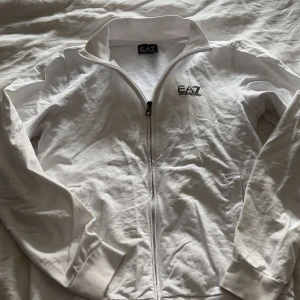 Vit tröja från EA7 - Säljer denna vita EA7 tröja. Lite skrynklig för den legat ett tag men annars är det inga problem på tröjan:)