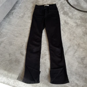 Jeans Gina Tricot Molly XS - Snygga svarta jeans modell Molly i storlek XS från Gina Trcot. Byxorna har en klassisk design med dragkedja och knapp framtill. Slits längst ned/fram på byxan. Bra skick!