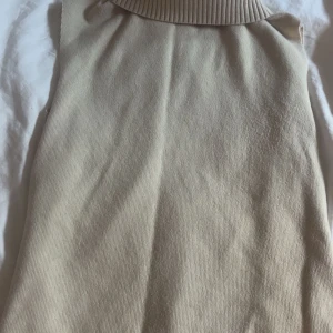 Beige polokrage armlös tröja - Snygg beige tröja med polokrage. Perfekt för lager-på-lager-stil under kyligare dagar. Enkel och stilren design som passar till det mesta. Helt ny, bara testad. Säljer pga att den inte kommer till användning. Kontakta vid funderingar💘