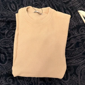 Beige stickad tröja från Zara - Säljer en beige stickad tröja från Zara i storlek M. Tröjan har rund halsringning och är långärmad med en clean, enkel design. Perfekt för lager-på-lager och passar till allt. Materialet är mjukt och ger en chill vibe.
