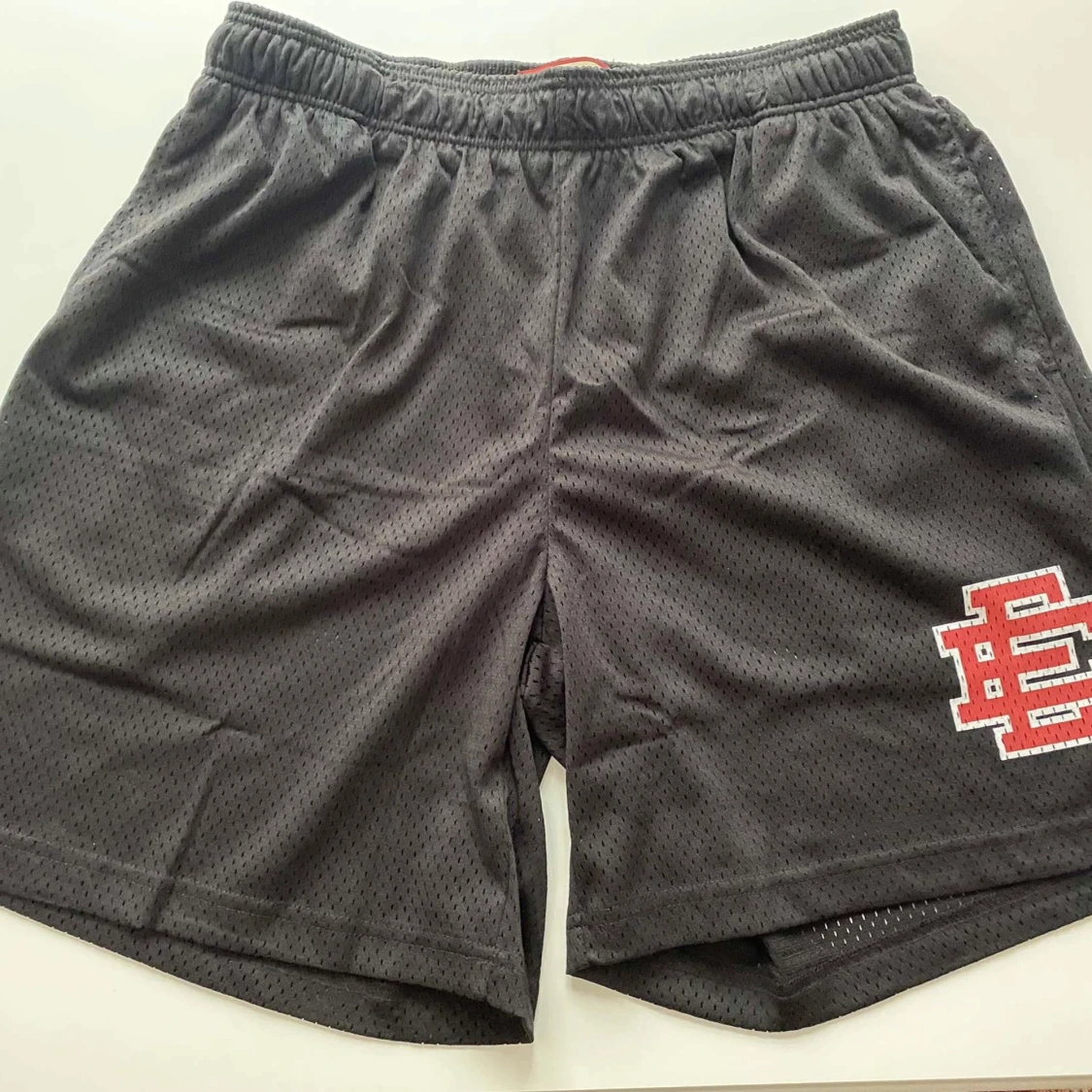 Svarta meshshorts med röd brodyr