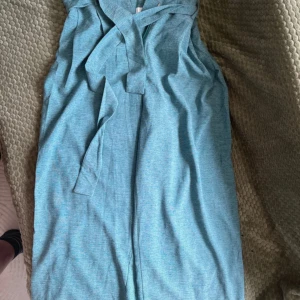 Blå Byxa från Vila - Snygg blå byxa från Vila med omlottknytning framtill. Byxan har en lätt melerad look. Perfekt för dig som gillar en stilren och fräsch vibe.