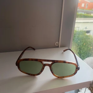 Coola solglasögon - Jättecoola solglasögon från GinaTricot. De har bruna bågar och ett grönt glas. Jättebra skick!