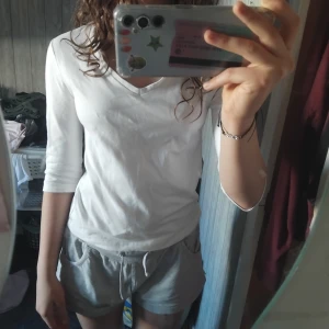 Vit v-ringad tröja med trekvartsärm - Säljer en enkel och stilren vit tröja med v-ringning och trekvartsärm. Tröjan har en normal passform och är gjord i mjuk bomull, perfekt för dig som gillar en clean och basic look. Passar till allt och är superbekväm att bära.