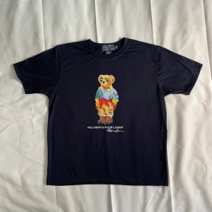 Polo Bear - Polo Ralph Lauren Polo Bear T-shirt – Marinblå – M Klassisk t-shirt med ikoniska Polo Bear. Stilren, bekväm och perfekt för både vardag och streetwear. 🔹 Storlek M 🔹 Färg: Marinblå 🔹 100 % bomull 🔹 Mycket fint skick – inga fläckar eller hål.  📦 Snabb leverans 📩 Hör av dig vid frågor!  #PoloBear #RalphLauren #Streetwear #Herrmode #StorlekM #VintageStil #PoloRalphLauren 