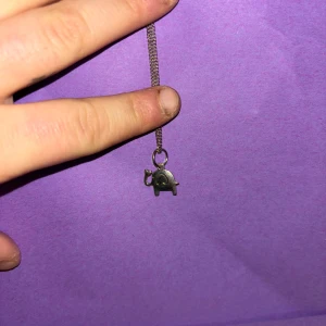 Sött silverfärgat halsband med elefant - Ett smalt silverfärgat halsband med en liten elefantberlock. Elefanten har ett hjärta på snabeln och en enkel, stilren design. Perfekt för dig som gillar djur och vill ha något gulligt och personligt runt halsen.