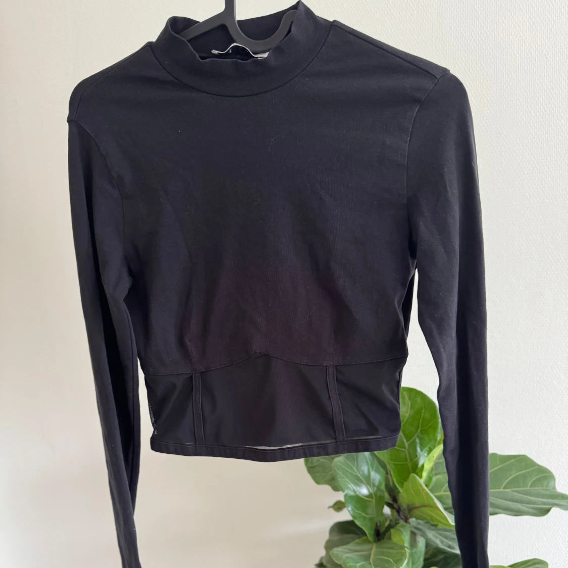 Svart croppad polotopp med meshdetalj