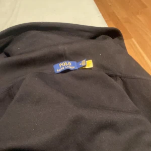 Svarta mjukisbyxor Polo Ralph Lauren - Svarta mjukisbyxor från Polo Ralph Lauren med klassisk broderad logga på benet. Byxorna är i mjukt material och har en avslappnad passform, perfekta för chill dagar. Snygg och enkel design med diskreta sömmar.