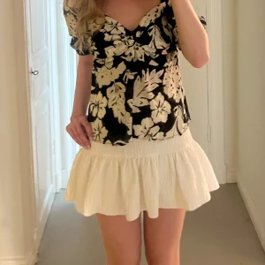 Vit volangkjol zara - Supersöt vit kortkjol med volang och bred resår i midjan. Inte stretchiga då de har inbyggda short under kjolen! Storlek xs men sitter som xs/s