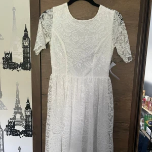 Vit spetsklänning Tinsey Lace Dress - Superfin vit spetsklänning från Tinsey med korta ärmar och vackert blommigt spetsmönster. Klänningen har rund halsringning fram och djup v-ringning i ryggen. Aldrig använd o har prislapp kvar köpt för 699