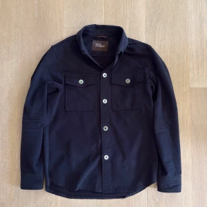 Overshirt Oscar Jacobsson  - Riktigt schysst overshirt från Oscar Jacobsson. Passar perfekt till en stilren lager på lager stil. Prutmån finns givetvis. Hör gärna av er vid frågor!