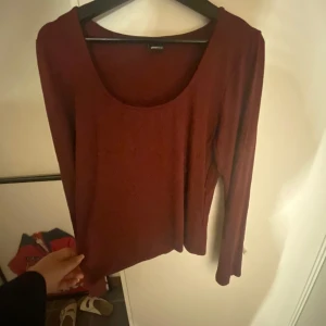Vinröd långärmad tröja Gina Tricot - Vinröd långärmad tröja från Gina Tricot med rund, djup ringning. Enkel och stilren modell i mjukt material, perfekt att matcha med jeans eller kjol. Snygg basic för garderoben! Helt ny aldrig använd har bara ta bort prislappen 