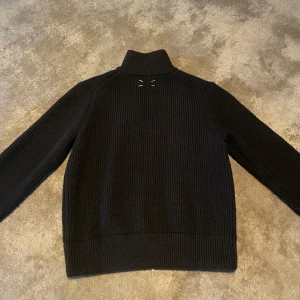 Maison Margiela zip tröja - Zip tröja från Maison Margiela, väldigt bra skick. Tröjan har ett flaw, tagen är lös i en kant (se bild 4). Skriv om du har fler frågor!