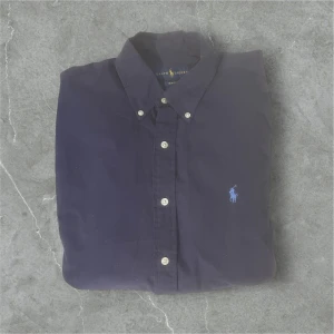 Mörkblå skjorta från Ralph Lauren - Snygg mörkblå skjorta från Ralph Lauren / skick 9/10 / storlek M / nypris ca 1700 / kontakta mig via intresse eller annat och pris kan diskuteras!😊🙏