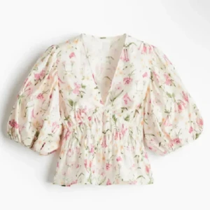 blommig blus med puffiga armar - Supersnygg blus från H&M med blommigt mönster. Endast använd en gång! Den är i storlek L men jag skulle säga att den passar som en M!