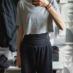 Grå croppad t-shirt - En enkel och stilren grå croppad t-shirt med korta ärmar. T-shirten har en avslappnad passform och är perfekt för en chill vardagslook. 