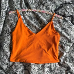 Orange croppad linnetopp - Snygg orange croppad linnetopp med smala axelband och v-ringning. Kan mötas upp i Norrköping 😊