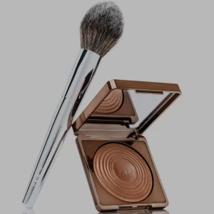 CAIA bronzer och sminkborste - Snygg bronzer från CAIA i en lyxig guldig/bronsig nyans med skimrande finish. Kommer i en stilren fyrkantig dosa med spegel. Medföljer en fluffig sminkborste med silverfärgat handtag och mjuka borststrån för enkel applicering.