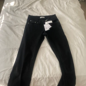 Svarta bootcut jeans från Gina Tricot -   Snygga, svarta bootcut jeans i storlek 34. Låg midja för en trendig look. Helt nya, endast testade – aldrig använda utomhus. Kommer direkt från butik och är i perfekt skick. Perfekta för dig som vill ha ett par bekväma och stilrena jeans!
