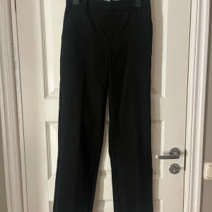 Svarta kostymbyxor från gina tricot - Säljer ett par svarta kostymbyxor i storlek 32, säljs inte längre på gina!