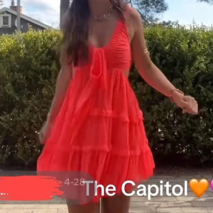 Korallrosa volangklänning med knyt - Supersöt korallrosa kortklänning med volanger och breda axelband. Djup v-ringning med knyt framtill och öppen rygg med snygga banddetaljer. Luftigt material, perfekt för varma dagar. Klänningen har flera lager och ger en flowy känsla. Inte mina bilder men är samma klänning.