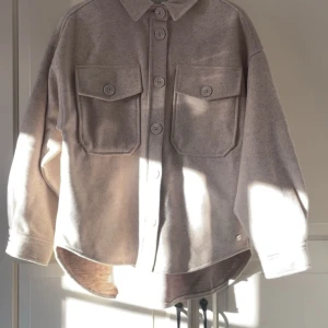 ZINK Beige stjortjacka  - Jättefin beige jacka från märket Zink med oversized passform. Storlek S (36/38).Den har stora bröstfickor med lock, knappar framtill och klassisk krage.