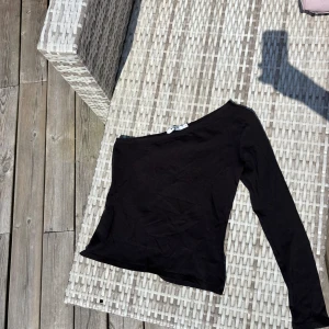Svart oneshoulder topp från NA-KD - Snygg svart oneshoulder topp från NA-KD i mjuk bomull. Långärmad och tight passform. 