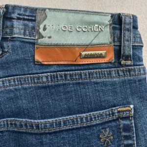 Jacob Cohen bard limited edition - Snygga blå jeans från Jacob Cohen i klassisk rak modell. I butik kostar jeansen cirka 10000 kr. Jeansen har normal passform, fem fickor och diskreta detaljer. Tillverkade i mjukt denimtyg som sitter skönt hela dagen. Perfekta för dig som gillar stilrena och tidlösa jeans. Den enda defekten är att några bokstäver har lossnat (kolla bild). 