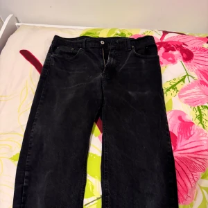 Svarta jeansbyxor från Mc Gordon - Svarta jeansbyxor från Mc Gordon med klassisk femficksdesign och raka ben. Byxorna har normal passform och stängs med dragkedja och knapp. Perfekta för dig som gillar en enkel och tidlös stil.  34/34