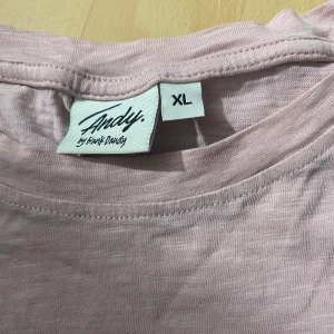 Ljusrosa t-shirt från Andy by Frank Dandy - Ljusrosa t-shirt från Andy by Frank Dandy i bomull. Klassisk modell med kort ärm och rund halsringning. Bröstficka på vänster sida och liten logolapp nertill. Perfekt basic till garderoben.